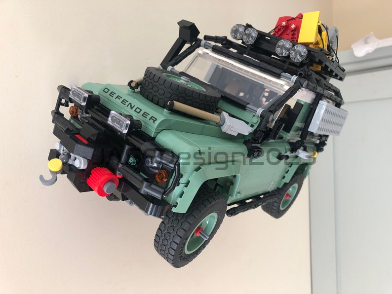 May include: A green Lego Land Rover Defender model with a black roof rack, spare tire, and a winch on the front bumper. The model has a detailed interior and exterior, including working headlights and taillights.