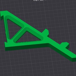 May include: A bright green, geometric 3D-printed object with a triangular opening and a rectangular base. The object has a unique, angular design and is set against a dark gray grid background.