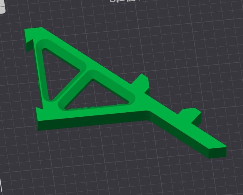 May include: A bright green, geometric 3D-printed object with a triangular opening and a rectangular base. The object has a unique, angular design and is set against a dark gray grid background.