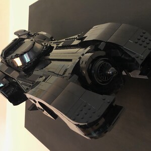 K&ouml;nnte beinhalten: Ein schwarzes Lego-Modell des Batmobils aus dem Batman-Film-Franchise. Das Modell ist detailliert und verf&uuml;gt &uuml;ber ein elegantes, aerodynamisches Design.