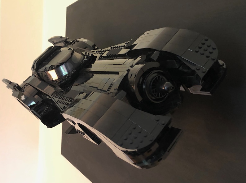 K&ouml;nnte beinhalten: Ein schwarzes Lego-Modell des Batmobils aus dem Batman-Film-Franchise. Das Modell ist detailliert und verf&uuml;gt &uuml;ber ein elegantes, aerodynamisches Design.