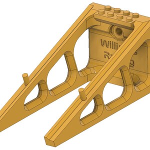 May include: A tan-colored, 3D-printed support structure with a series of angled beams and cut-out sections. The structure has two cylindrical pegs and a top section with eight circular studs. The text "Williams R" is visible on the side.