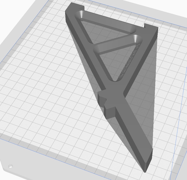 May include: A gray 3D printed triangular shelf bracket with a geometric design. The bracket is designed to be mounted to a wall.