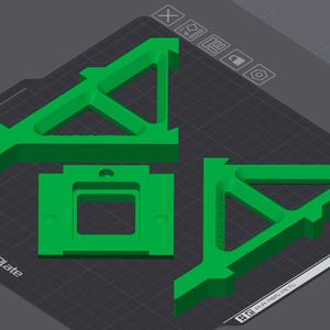 Op de afbeelding: Drie felgroene 3D-geprinte componenten worden weergegeven op een donkergrijze, getextureerde ondergrond. De componenten omvatten twee hoekbeugels en een rechthoekig stuk met een vierkante uitsparing. De onderdelen zijn waarschijnlijk voor een grotere assemblage.