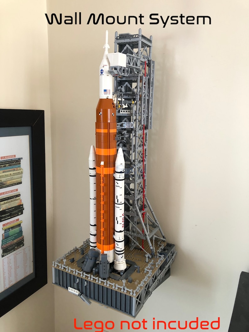 May include: A wall mount system for a Lego space shuttle model. The system is made of gray metal and has a platform for the shuttle to sit on. The shuttle is not included.
