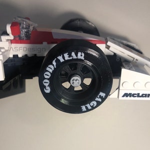 Op de afbeelding: Een wit, rood en zwart racewagenmodel met een Goodyear-band. Het model heeft het Shell-logo en het McLaren-logo. De tekst "JASFDesign" is zichtbaar aan de zijkant.