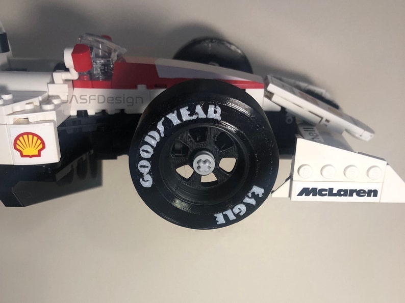 Op de afbeelding: Een wit, rood en zwart racewagenmodel met een Goodyear-band. Het model heeft het Shell-logo en het McLaren-logo. De tekst "JASFDesign" is zichtbaar aan de zijkant.