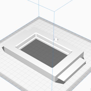 May include: A white plastic frame with a rectangular opening and a small round hole on the top. The frame has a step on the bottom.