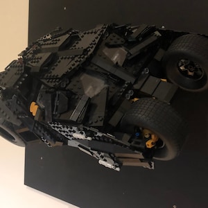 May include: A black Lego model of the Batmobile from the Batman movie series. The model is detailed and includes working wheels.
