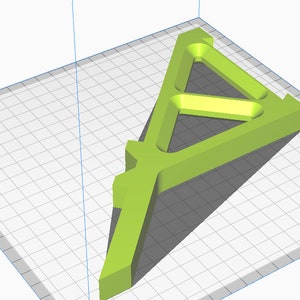 May include: A green plastic 3D printed object shaped like a triangle with a hollow center. The object is designed to be used as a stand or support.