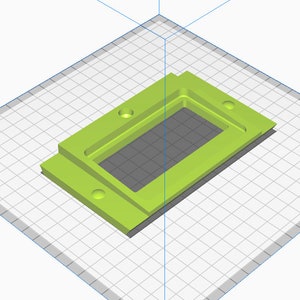 May include: A green plastic rectangular box with a cutout in the center. The box has four holes on the sides.