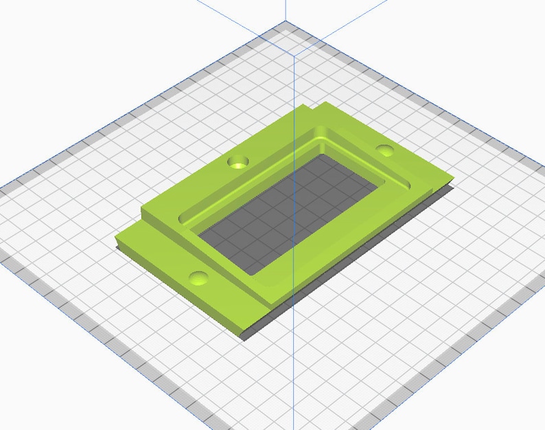May include: A green plastic rectangular box with a cutout in the center. The box has four holes on the sides.