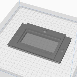 May include: Gray plastic mold with a rectangular cutout and the text "Mercedes-AMG F1" on the bottom.