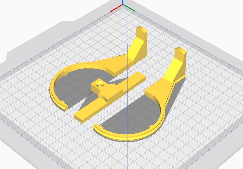 May include: A 3D-rendered image of three yellow plastic components. The components appear to be parts of a larger structure, with curved and rectangular shapes. The parts are arranged on a grid-like surface, suggesting a design or modeling environment.