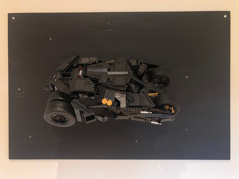 May include: A black Lego model of the Batmobile from the Batman movie franchise. The model is displayed on a black background.