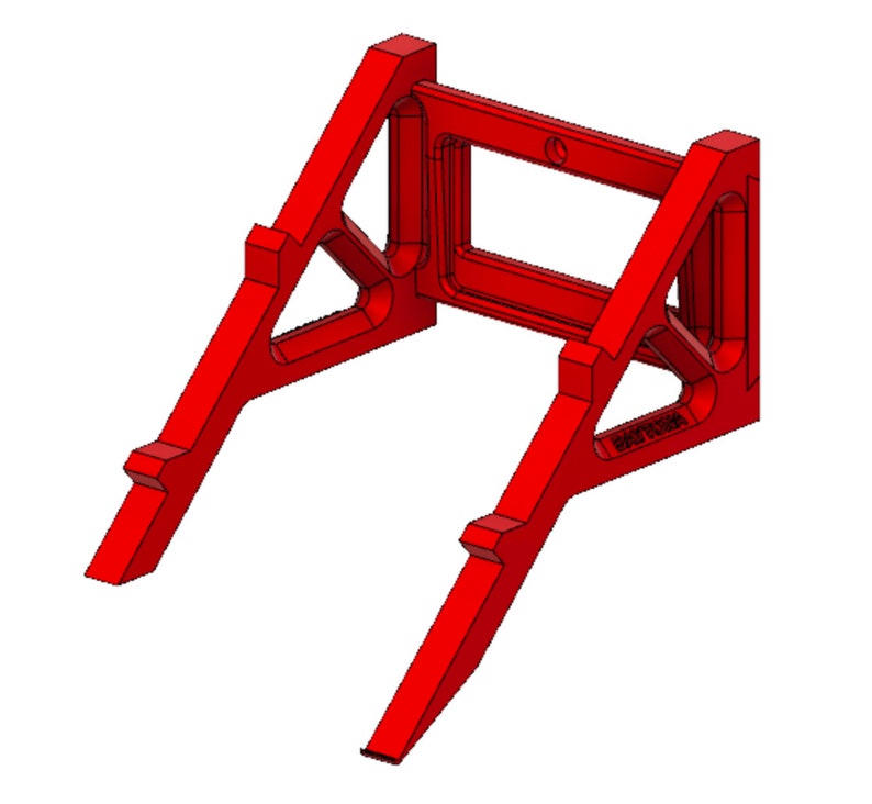 May include: A red plastic wall mount with a rectangular opening in the centre. The mount has a triangular shape on each side and is designed to hold a device.