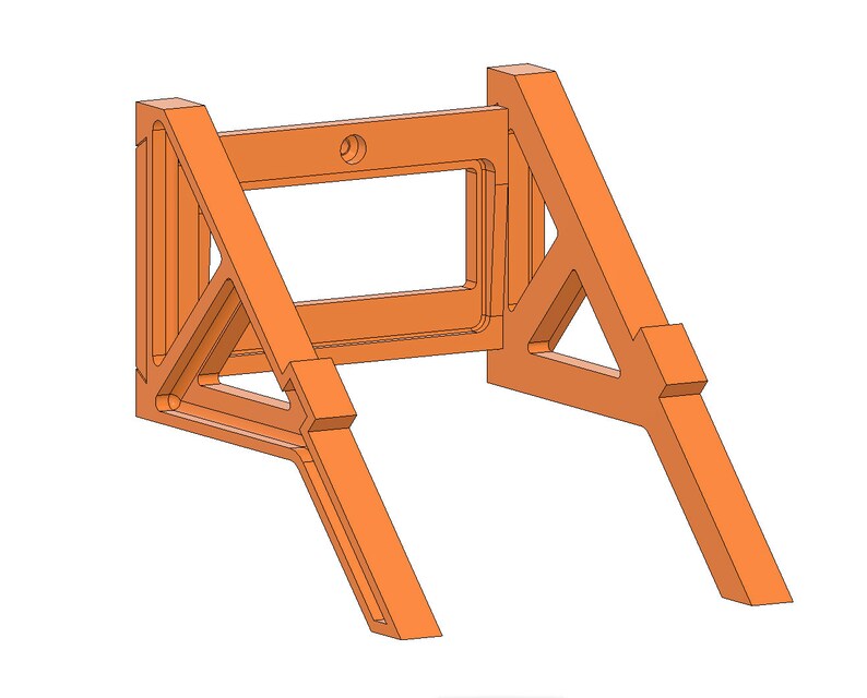 May include: Orange plastic wall mount with a rectangular opening in the center. The mount is designed to hold a device or object.