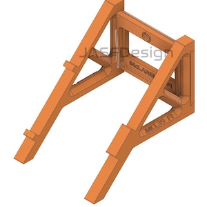May include: An orange-colored, angled bracket with the text "JAS Design" and "McLaren" visible. The bracket has a rectangular opening and is designed with structural supports. The text "MCL39 A" is also visible.