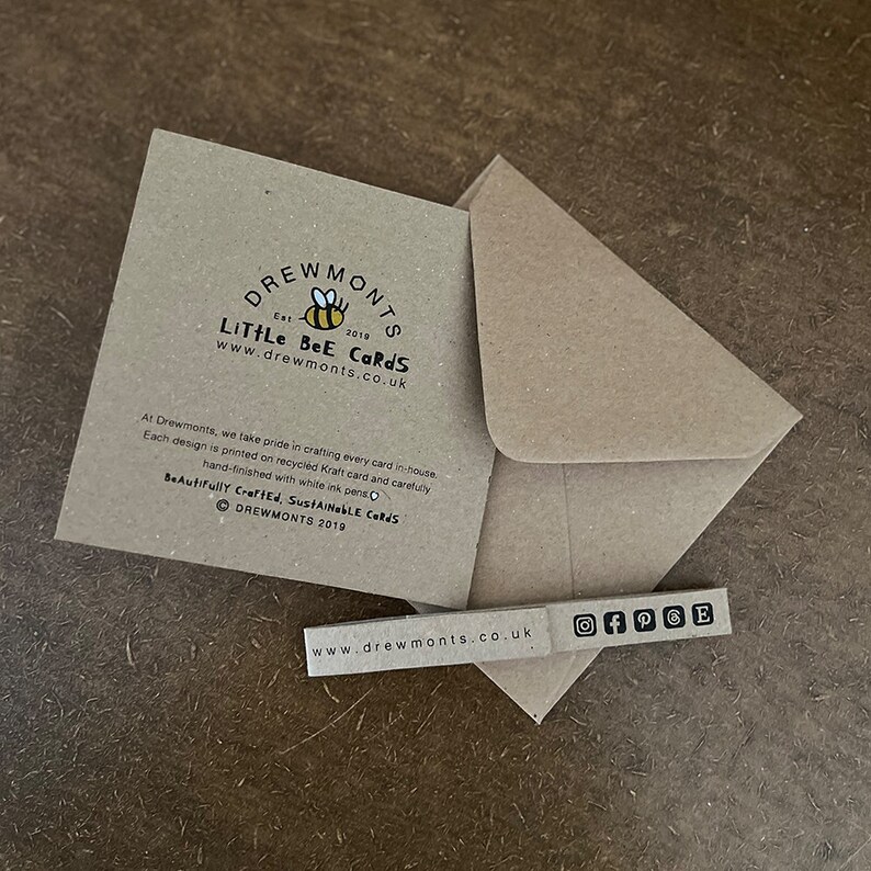 May include: A brown card with a bee illustration and the text "Drewmonts Little Bee Cards" and "www.drewmonts.co.uk". The card also includes the text "Beautifully Crafted, Sustainable Cards" and "Drewmonts 2019".