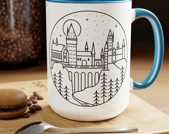 May include: White ceramic mug with a blue rim and handle. The mug features a black line drawing of Hogwarts castle in a circle against a white background.