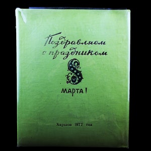 May include: A green book with the text "Поздравляем с праздником 8 марта!" (Congratulations on the holiday of March 8!) and "Харьков 1977 год" (Kharkiv 1977).