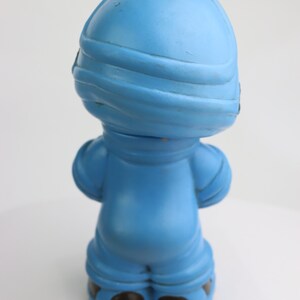 K&ouml;nnte beinhalten: Eine blaue Plastikfigur eines Menschen, der einen Helm und einen Overall tr&auml;gt. Die Figur steht mit den Armen an den Seiten.