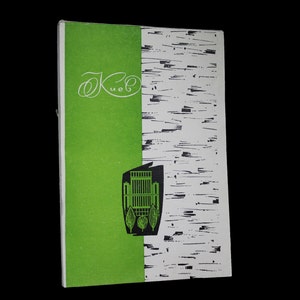 May include: A green and white book cover with the text "Ок" in cursive and a black and white illustration of a building with trees.