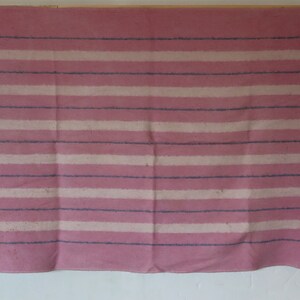 Puede incluir: Una manta de rayas rosa y blancas con rayas azules. La manta est&aacute; hecha de un tejido suave y tejido.