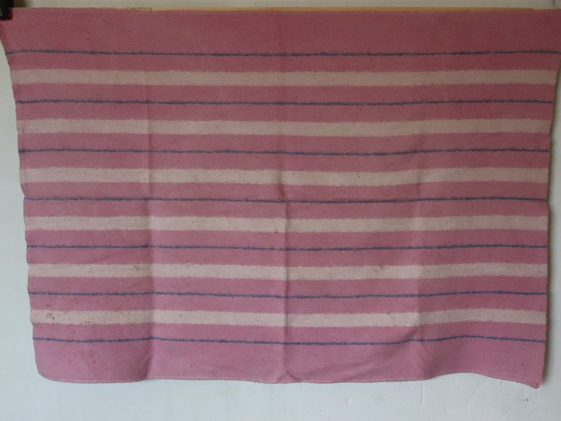 Puede incluir: Una manta de rayas rosa y blancas con rayas azules. La manta est&aacute; hecha de un tejido suave y tejido.
