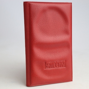 May include: A red leather notebook with the word "МОСКВА" embossed on the front.