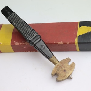 May include: A black and gold glass cutter with a black plastic handle. The cutter is in a red and yellow box with black lettering that says "HARTMANN".
