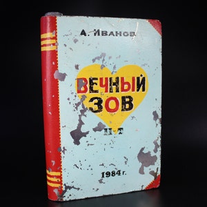 May include: A vintage, blue, and yellow book with a red spine. The book cover features a heart with the text "Вечный Зов" in black letters. The book title is "Вечный Зов" and the author is "А. Иванов". The book was published in 1984.