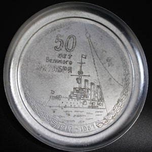 May include: A silver commemorative plate with a ship and the text "50 лет Великого Октября 1917 - 1967".