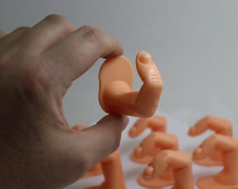 May include: A set of eight flesh-toned finger mannequins for displaying nail art and jewelry. The mannequins are made of a soft, flexible material and are designed to look like real fingers.