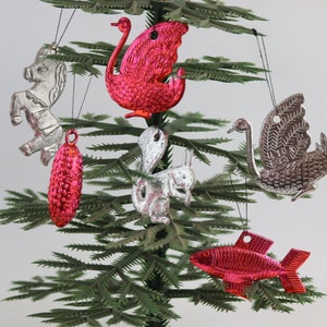 Könnte beinhalten: Eine Sammlung von Vintage-Weihnachtsbaumschmuck mit einem silbernen Einhorn, einem silbernen Schwan, einem rosa Schwan, einem rosa Fisch, einem silbernen Eichhörnchen und einem rosa-silbernen Perlenornament.