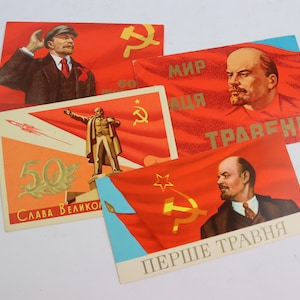 May include: Four vintage Soviet propaganda postcards featuring portraits of Lenin and a red flag with a hammer and sickle. The text on the postcards includes "Мир труд" and "Перше Травня".