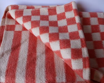 Peut inclure: Une couverture à carreaux rouges et blancs pliée en deux. La couverture est faite d'un matériau doux et duveteux.