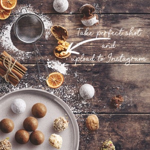 May include: A plate of chocolate truffles with a variety of toppings, including nuts and sprinkles. The truffles are arranged on a white plate with a wooden background. There is a bowl of powdered sugar and a cinnamon stick on the table. The text "Take perfect shot and upload to Instagram" is written on the image.
