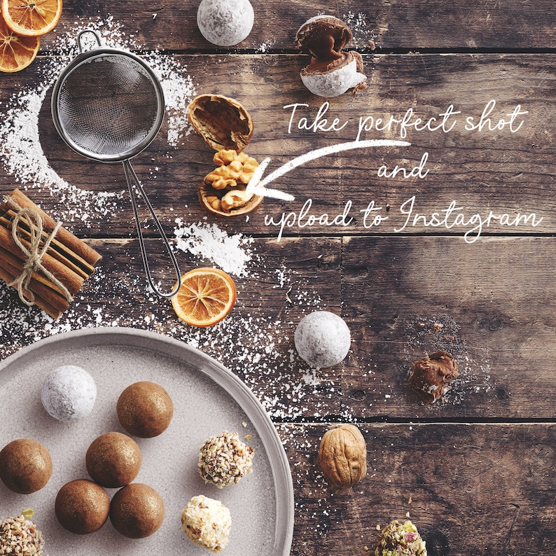 May include: A plate of chocolate truffles with a variety of toppings, including nuts and sprinkles. The truffles are arranged on a white plate with a wooden background. There is a bowl of powdered sugar and a cinnamon stick on the table. The text "Take perfect shot and upload to Instagram" is written on the image.