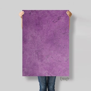 May include: A large purple textured poster with a subtle marbled effect. The poster is being held by a person.