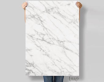 May include: A white marble background with grey veining. The marble is smooth and polished.