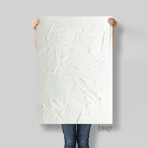 May include: A white textured canvas painting with a white background and a white paint texture. The painting is signed "Lovaco" in the bottom right corner.