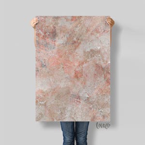 Op de afbeelding: Een rechthoekig paneel met een marmerachtig patroon in roze, beige en grijstinten. Het paneel wordt door een persoon omhoog gehouden, waarbij de onderste helft van hun lichaam zichtbaar is. Het woord "lovaco" staat rechtsonder.