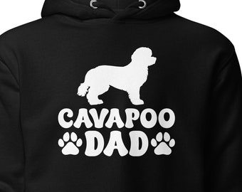 May include: Black hooded sweatshirt with a white silhouette of a Cavapoo dog and the text "Cavapoo Dad" with paw prints.