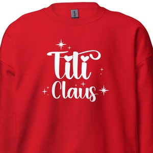 May include: Red sweatshirt with white text that says "Titi Claus" with two hearts and stars.