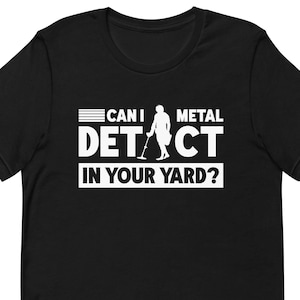 May include: Black t-shirt with white text that reads "Can I Metal Detect In Your Yard?" with a silhouette of a person holding a metal detector.