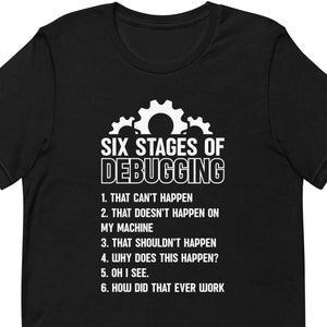 May include: Black t-shirt with the text "SIX STAGES OF DEBUGGING" and a gear graphic. The text lists the stages of debugging, including "THAT CAN'T HAPPEN" and "HOW DID THAT EVER WORK".