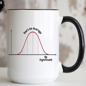 May include: White ceramic mug with a black handle and rim. The mug features a red bell curve graph with the text "Don't be Average" and "Be Significant". The mug has a glossy finish.