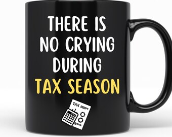 May include: Black coffee mug with white text that reads "There is no crying during tax season". A yellow calculator and tax form are pictured below the text.