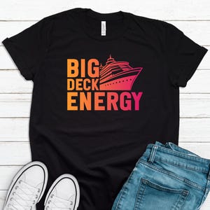May include: Black t-shirt with a graphic of a cruise ship and the text "BIG DECK ENERGY" in a gradient of orange, yellow, and pink.